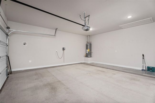 Garage with gas water heater, a garage door opener, baseboards, and recessed lighting | Image 29