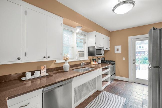 Main level kitchen with solid surface counters and stainless steel appliances. | Image 11