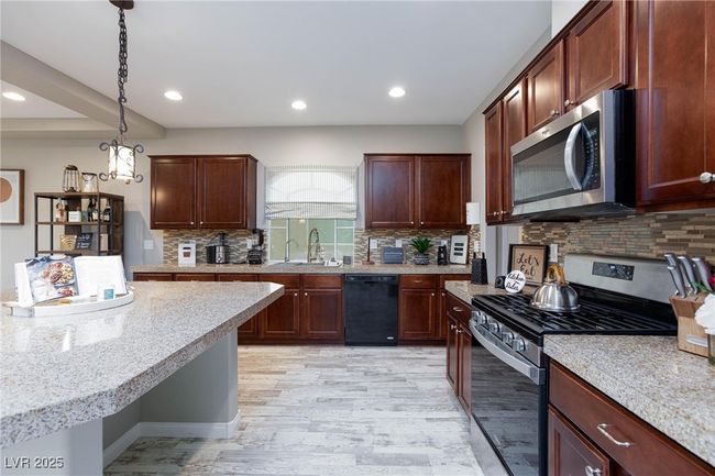 Kitchen featuring recessed lighting, a sink, pendant lighting, light wood-style flooring, and appliances with stainless steel finishes | Image 14