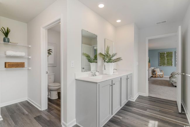 Bathroom featuring wood finished floors, double vanity, baseboards, toilet, and connected bathroom | Image 19