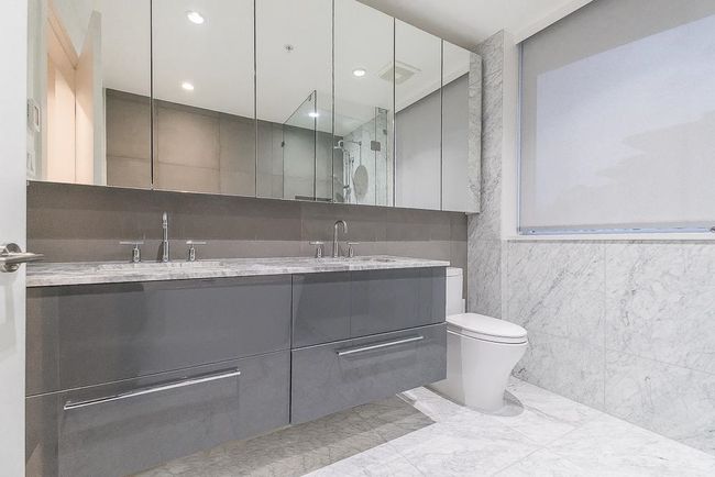 Bathroom with tile walls, marble finish floor, a sink, and toilet | Image 21