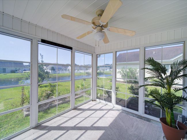 Sunroom featuring a water view, ceiling fan, and plenty of natural light | Image 4
