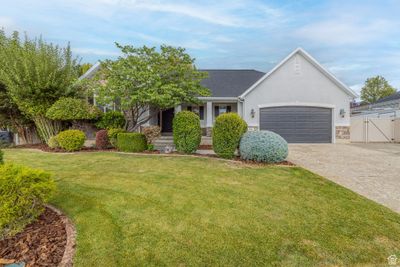 View of front facade featuring a front yard and a garage | Image 1