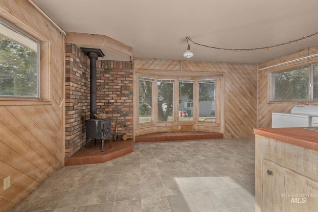 Unfurnished sun/craft room with utility area, separate wood stove | Image 18