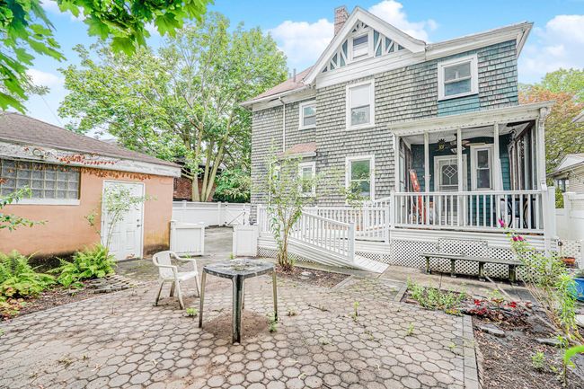 Rear view of house featuring a patio, a chimney, a sunroom, a wooden deck, and a ceiling fan | Image 24
