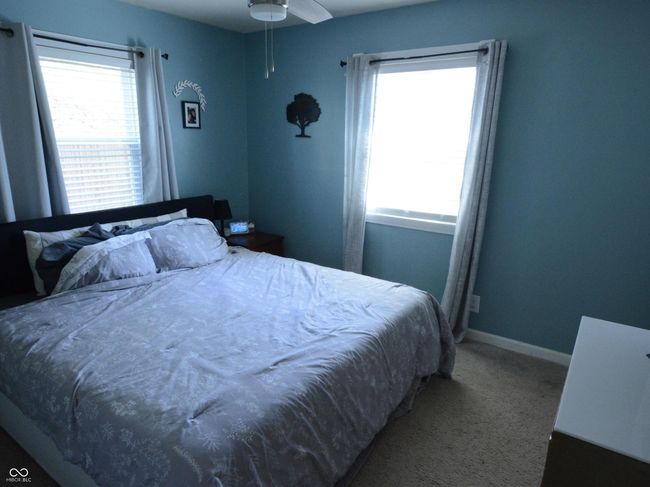 bedroom with baseboards, a ceiling fan, carpet flooring, and multiple windows | Image 19