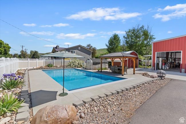 View of pool featuring a gazebo, a patio, a fenced backyard, and an outbuilding | Image 31