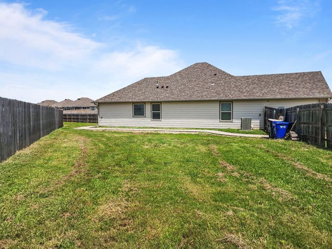 Rear view of property featuring a fenced backyard and roof with shingles | Image 37