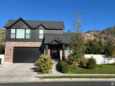 View of front of home featuring a front yard, a mountain view, and a garage | Image 1