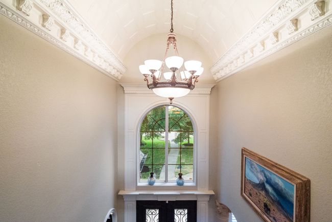 Foyer entrance featuring a chandelier and vaulted ceiling | Image 13