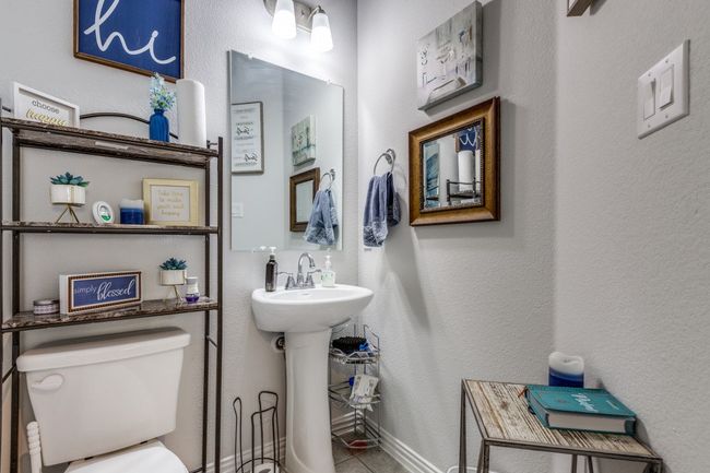 Half bath featuring toilet, a textured wall, and a sink | Image 19