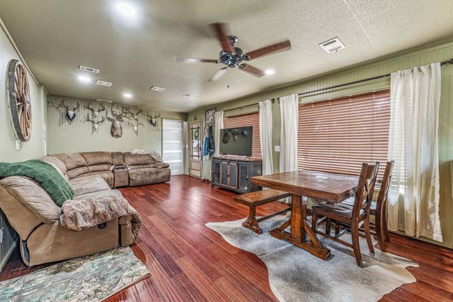 Living room featuring wood finished floors, a ceiling fan, visible vents, and a textured ceiling | Image 24