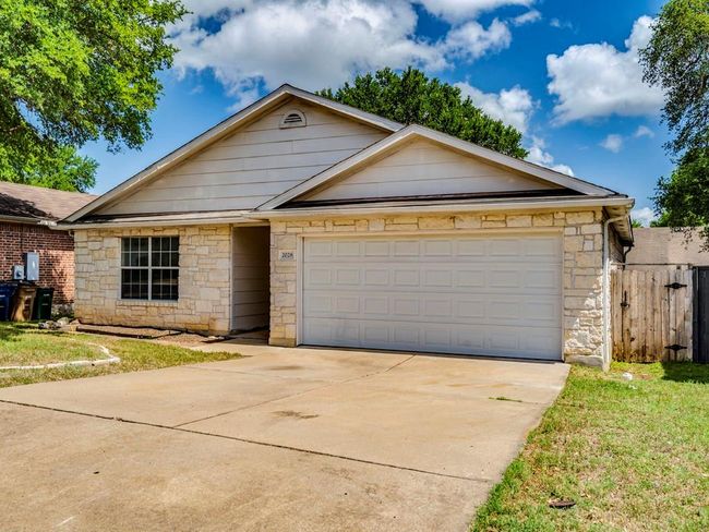Ranch-style house featuring stone siding, driveway, and an attached garage | Image 5