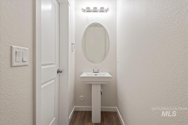 Half bath with a textured wall and wood finished floors | Image 15