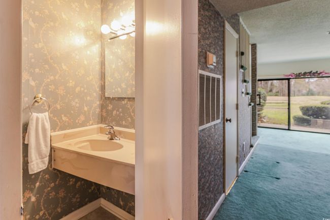 Bathroom featuring a sink, visible vents, a textured ceiling, and wallpapered walls | Image 9