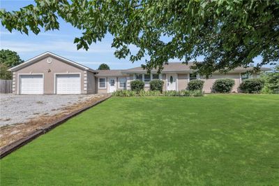 Ranch-style home with a garage and a front yard | Image 1