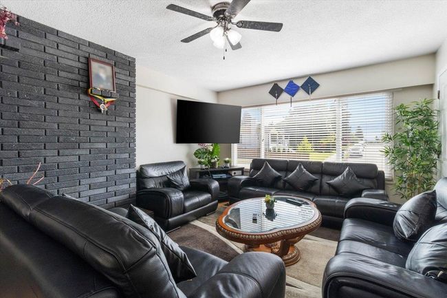 Carpeted living area with a textured ceiling and a ceiling fan | Image 8