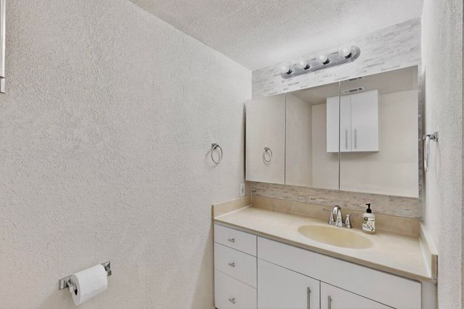 Bathroom with a textured wall, vanity, and a textured ceiling | Image 28
