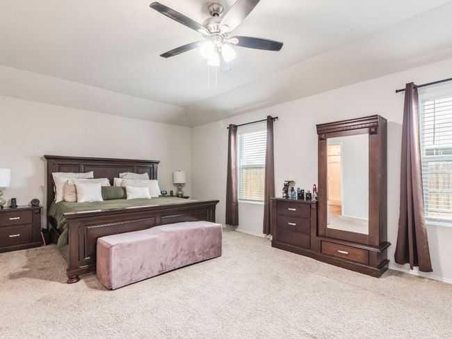 Bedroom featuring carpet flooring, ceiling fan, vaulted ceiling, and multiple windows | Image 16