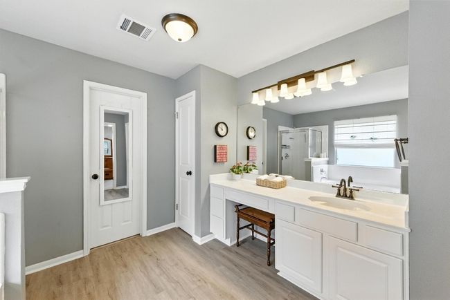 Full bathroom with wood finished floors, a stall shower, vanity, and a bath | Image 20