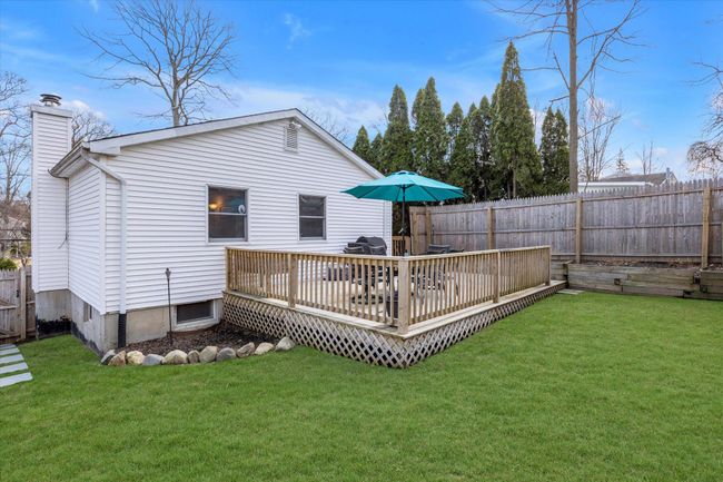 Rear view of home and fenced in yard, with a deck. | Image 17