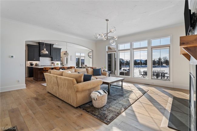 Living room featuring ornamental molding, a chandelier, and hardwood / wood-style flooring | Image 5