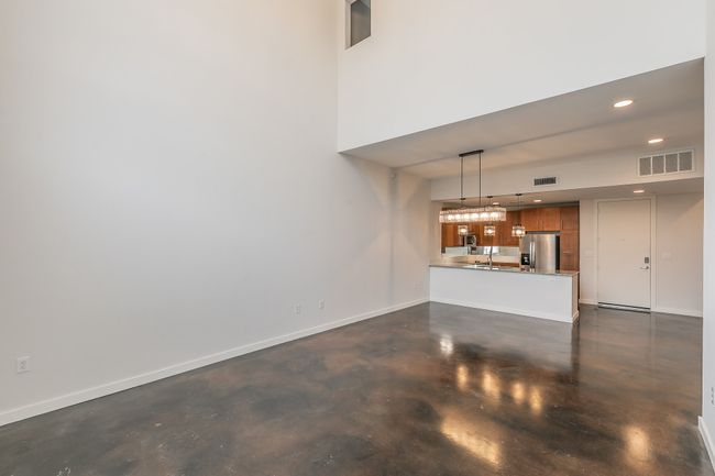 With expansive wall space and open sightlines to the kitchen, this double-height living area offers the perfect blend of modern minimalism and inviting warmth—ready for your personal touch. | Image 6