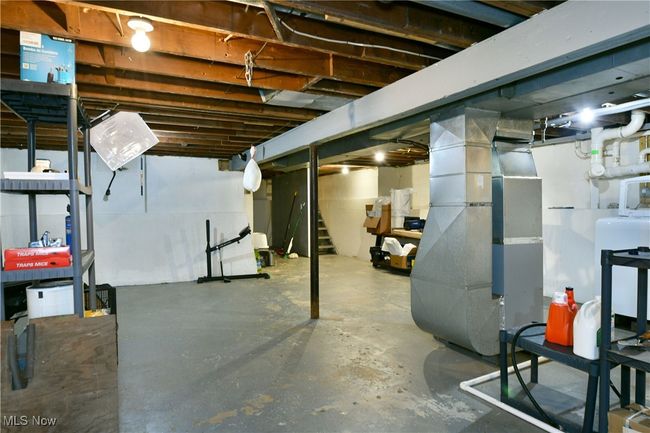 Unfinished basement featuring heating unit and stairway | Image 39