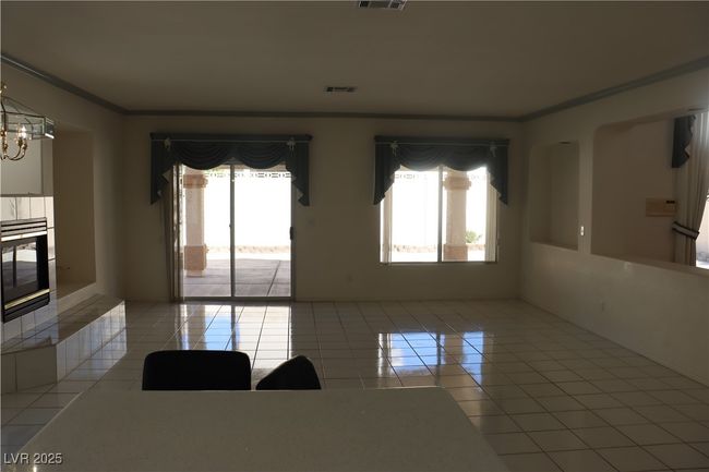 Unfurnished room with tile patterned floors, plenty of natural light, ornamental molding, and a chandelier | Image 58