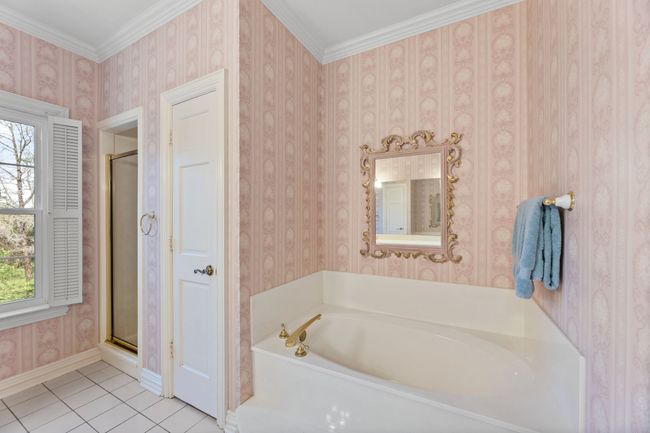 Bathroom featuring a garden tub, an enclosed shower, and ornamental molding | Image 27