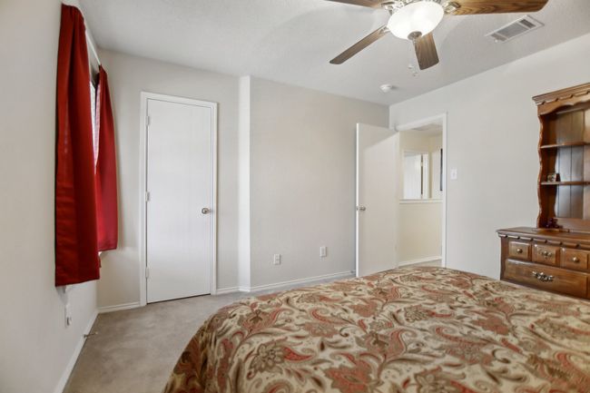 Carpeted bedroom with baseboards, visible vents, and a ceiling fan | Image 26