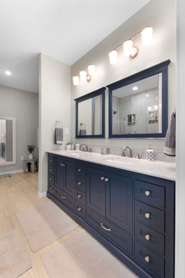 Primary Bathroom featuring double vanity, wood finished floors, baseboards, and a sink | Image 13