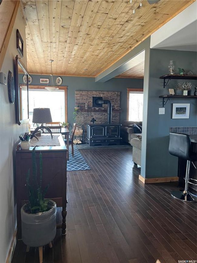 Living room featuring wood ceiling, wood-type flooring, a wood stove, and baseboards | Image 14