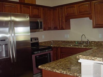 Kitchen featuring light stone countertops, stainless steel appliances, and sink | Image 3