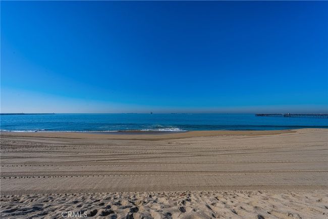 Tranquil oceanfront view showcasing golden sand, gentle waves, and a peaceful horizon | Image 10