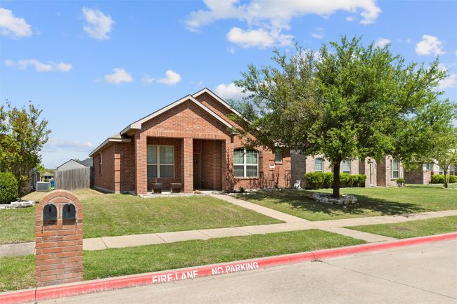 View of front of home featuring a front yard, brick siding, and fence | Image 4