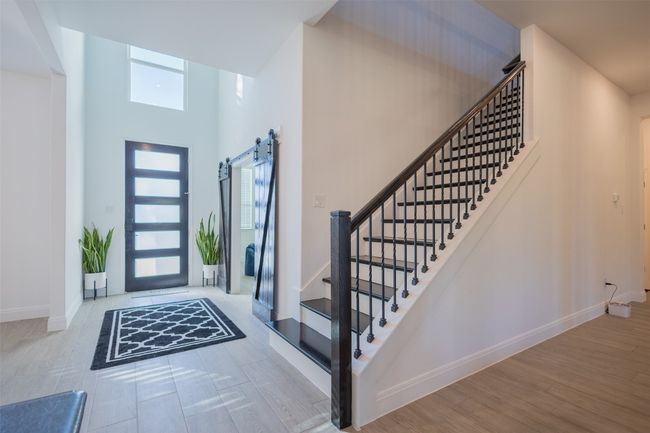 A great amount of natural light and a look at the barn door entrance to the front room. | Image 6
