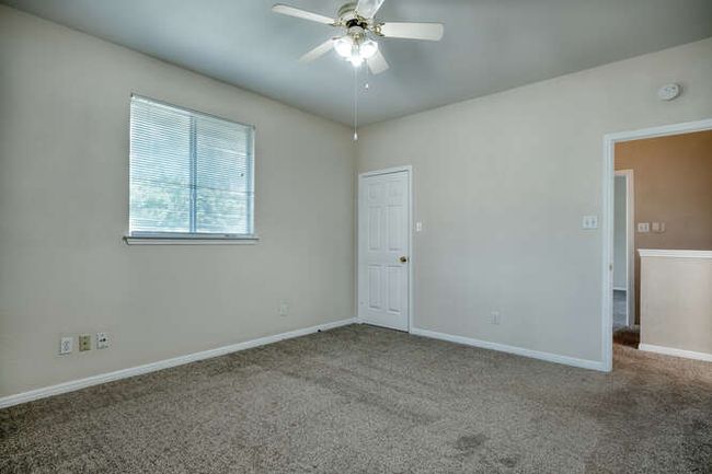 Carpeted spare room featuring ceiling fan, baseboards, and a smoke detector | Image 10
