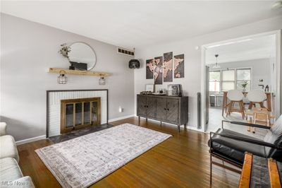 Living room featuring a brick fireplace and dark hardwood floors | Image 2