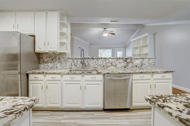 KItchen that opens to the den with granite countertops. | Image 9