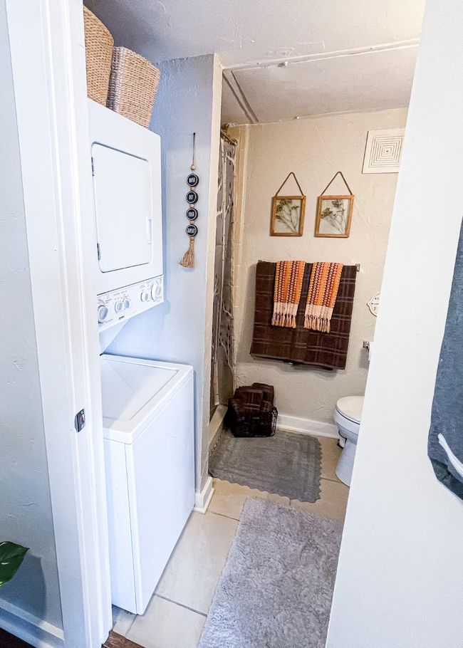 Bathroom with baseboards, visible vents, stacked washer / drying machine, tile patterned floors, and toilet | Image 15