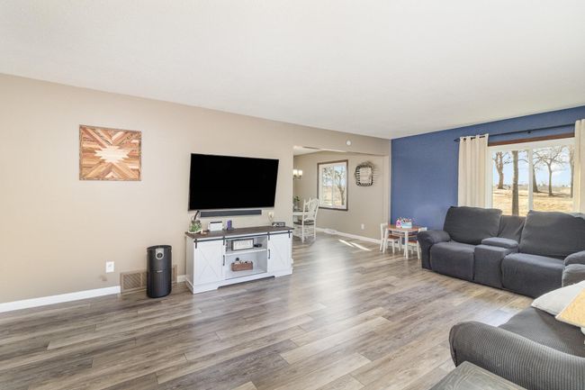 Spacious main-floor living room featuring brand-new LVP flooring and oversized windows for abundant natural light! | Image 4
