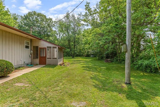 View of grassy yard with a sunroom | Image 9