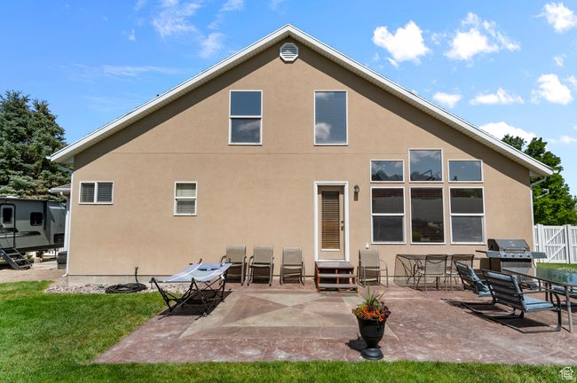 Back of property with stucco siding, entry steps, and a patio area | Image 24