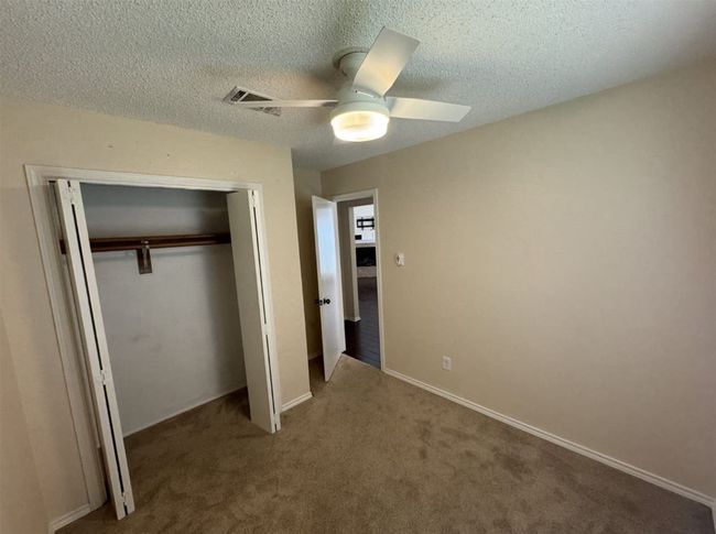 Unfurnished bedroom with a closet, a textured ceiling, carpet floors, and ceiling fan | Image 26
