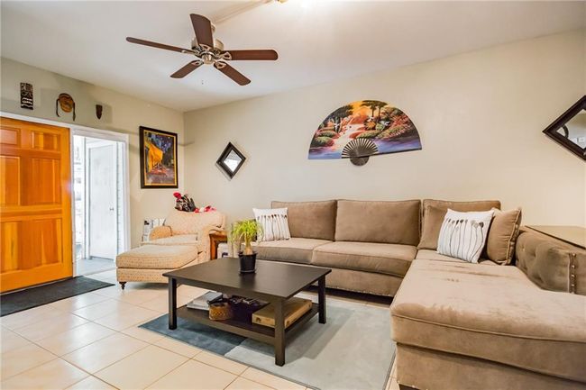 Living area with ceiling fan and light tile patterned flooring | Image 4