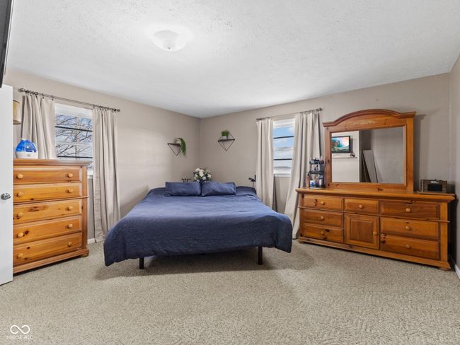 bedroom featuring carpet floors, a textured ceiling, and multiple windows | Image 18