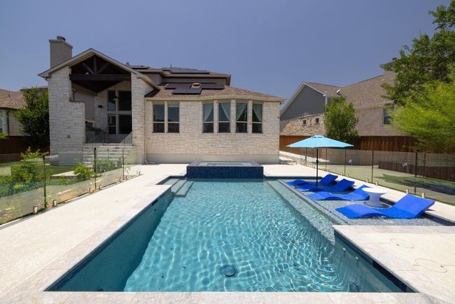 View of pool featuring a patio, a fenced backyard, and a pool with connected hot tub | Image 39