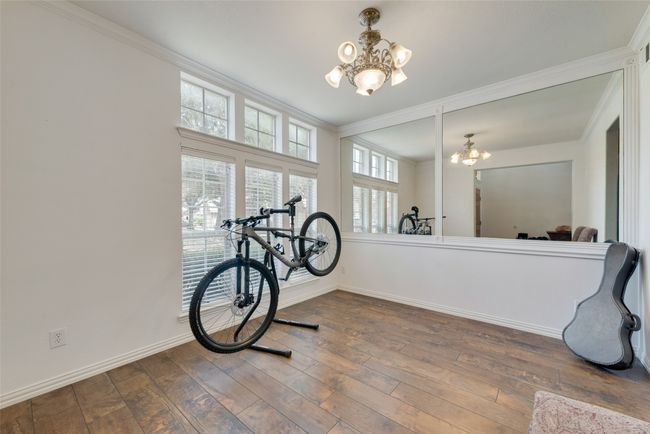 Dining room featuring baseboards, an inviting chandelier, ornamental molding, and wood finished floors | Image 5