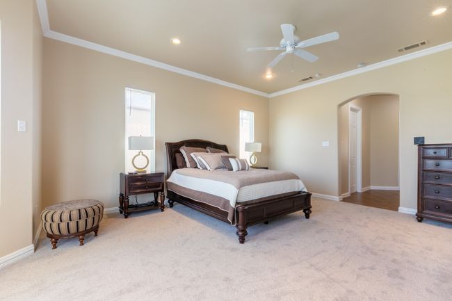 Carpeted bedroom with arched walkways, ornamental molding, recessed lighting, and a ceiling fan | Image 23